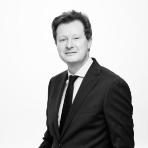 Black and white photograph of man in suit facing camera side on