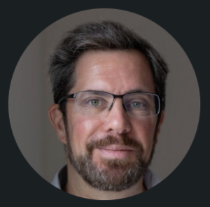Headshot of bearded man wearing glasses facing camera